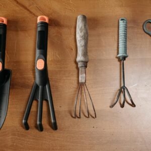 A collection of garden tools arranged on a wooden surface for easy plant care.